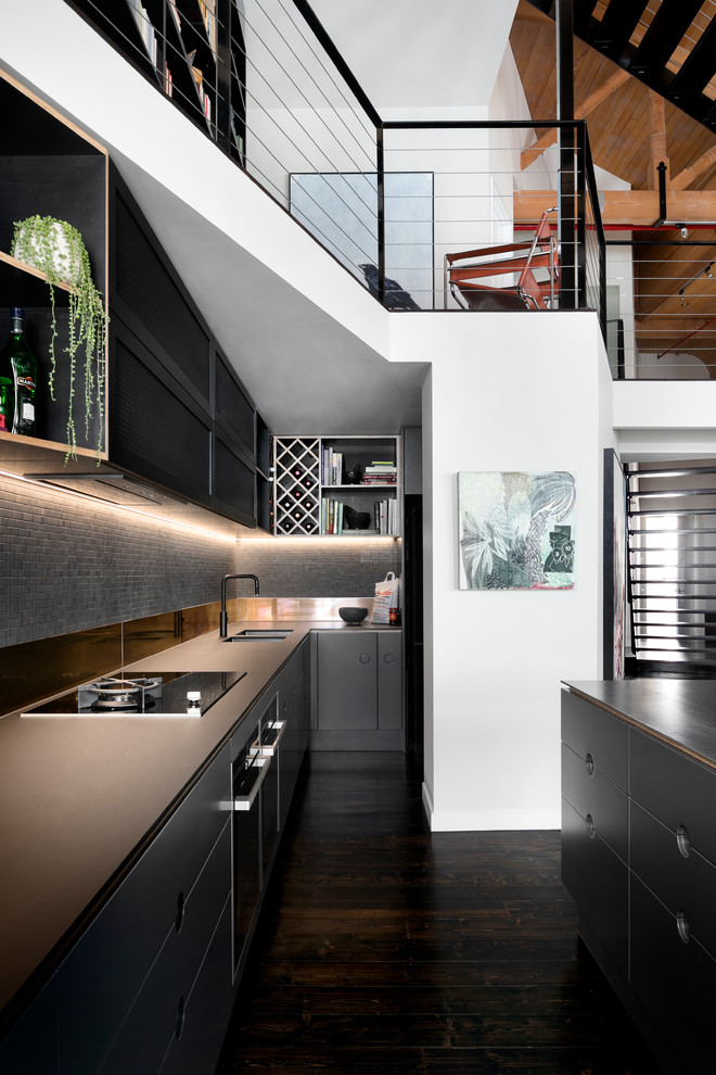 Inspiration for an urban galley kitchen in Melbourne with a submerged sink, flat-panel cabinets, black cabinets, grey splashback, mosaic tiled splashback, dark hardwood flooring, an island, brown floors and brown worktops.