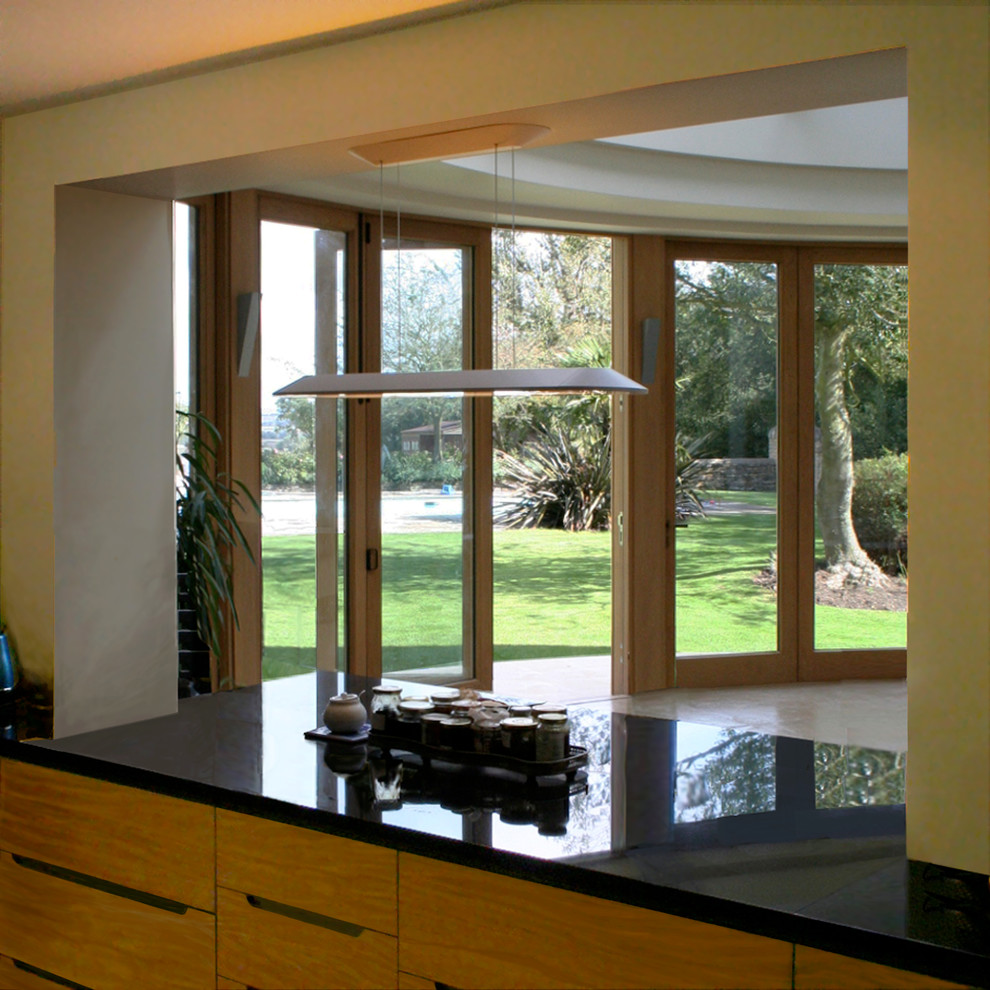Foto di una grande cucina minimal con ante lisce, ante in legno scuro, top in granito e pavimento in cemento