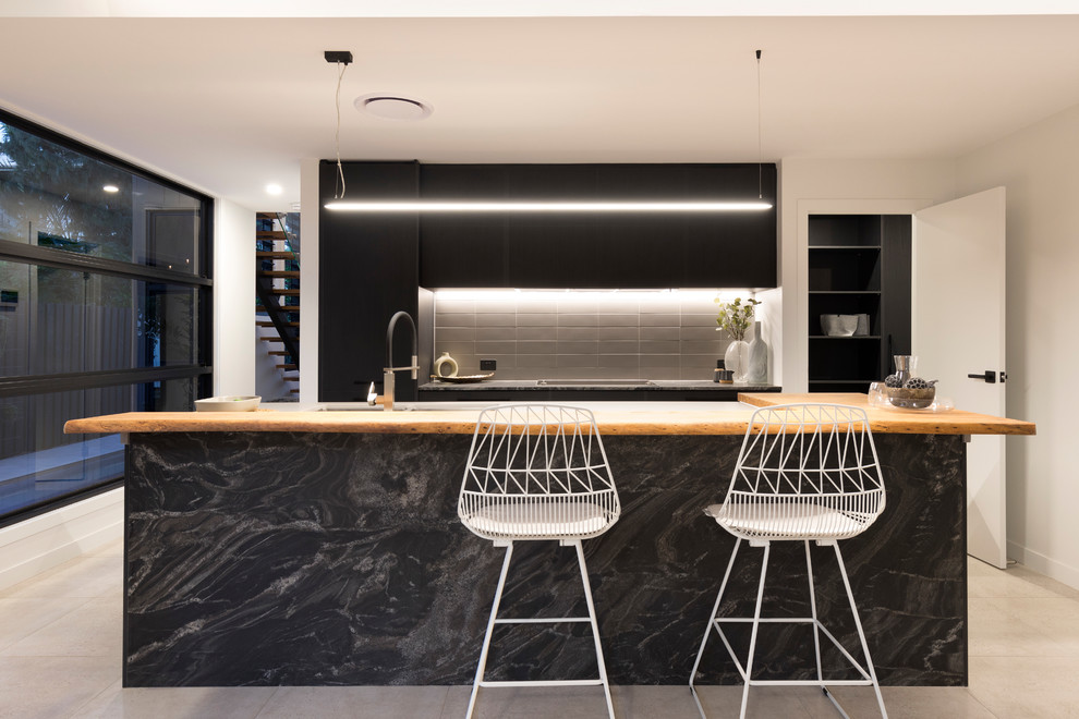 Inspiration for a contemporary galley kitchen in Brisbane with flat-panel cabinets, black cabinets, black splashback and an island.