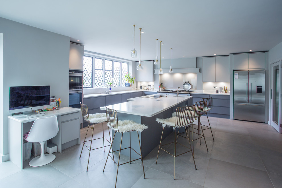 Große Moderne Küche in L-Form mit Unterbauwaschbecken, flächenbündigen Schrankfronten, grauen Schränken, Küchengeräten aus Edelstahl, Kücheninsel, grauem Boden und weißer Arbeitsplatte in Surrey