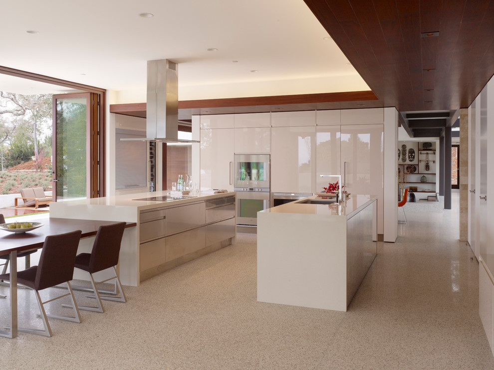 Eat-in kitchen - large modern u-shaped eat-in kitchen idea in San Francisco with stainless steel appliances, an undermount sink, flat-panel cabinets, white cabinets and two islands