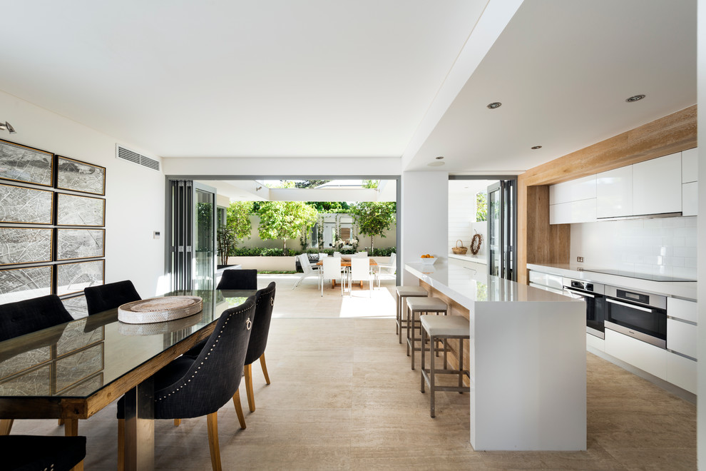 Moderne Küche mit flächenbündigen Schrankfronten, weißen Schränken, Küchenrückwand in Weiß, Küchengeräten aus Edelstahl und Rückwand aus Metrofliesen in Perth