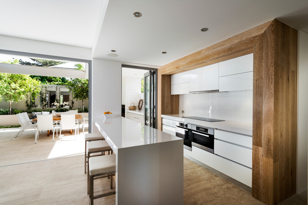 Moderne Küche mit flächenbündigen Schrankfronten, weißen Schränken, Küchenrückwand in Weiß, Rückwand aus Metrofliesen und Küchengeräten aus Edelstahl in Perth