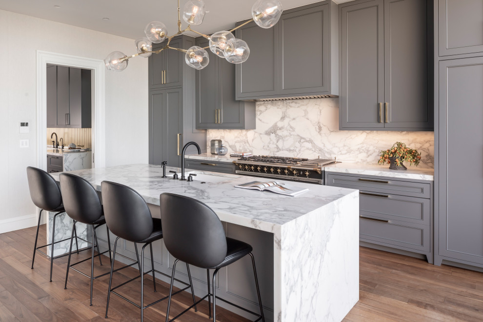 Mid-sized transitional medium tone wood floor eat-in kitchen photo in San Francisco with gray cabinets, marble countertops, marble backsplash, an island and white countertops