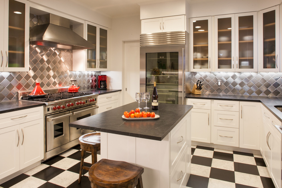 Idéer för ett modernt u-kök, med bänkskiva i täljsten, rostfria vitvaror, stänkskydd med metallisk yta, stänkskydd i metallkakel, luckor med glaspanel, vita skåp och flerfärgat golv