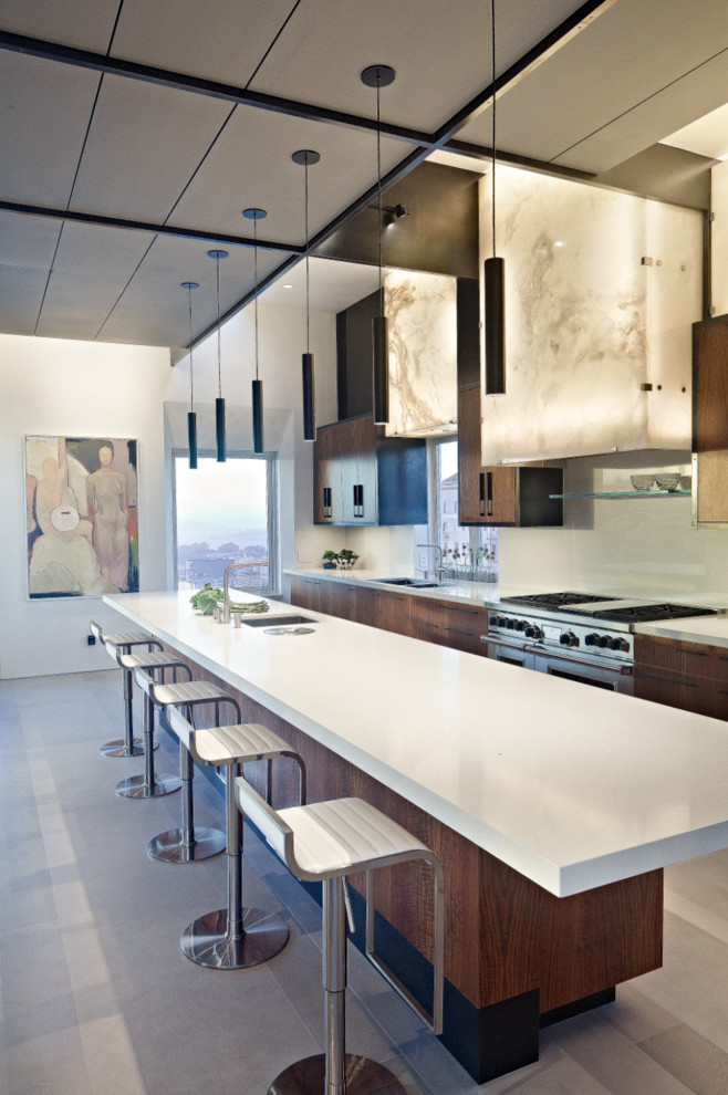 Immagine di una cucina design con lavello sottopiano, ante in legno scuro e elettrodomestici in acciaio inossidabile