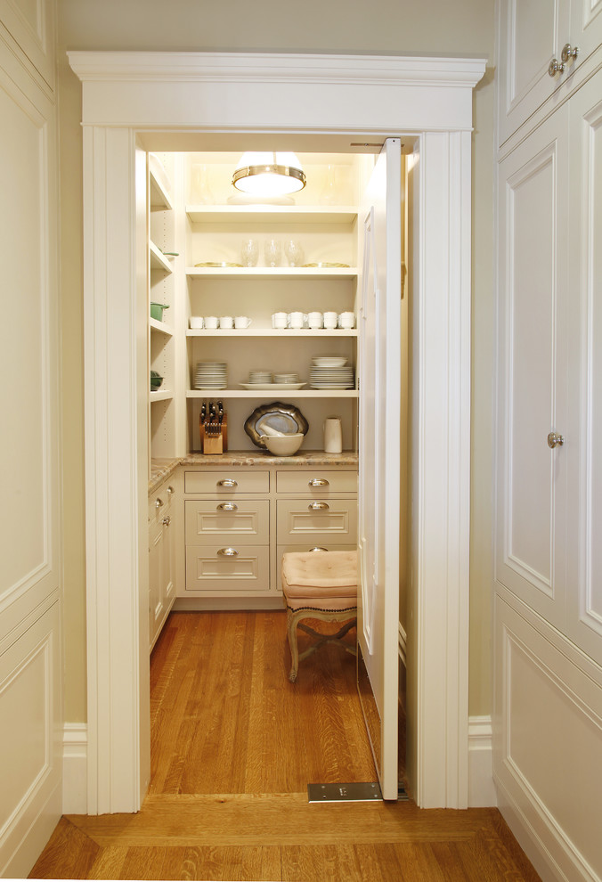 Inspiration pour une arrière-cuisine traditionnelle avec un placard sans porte et des portes de placard blanches.