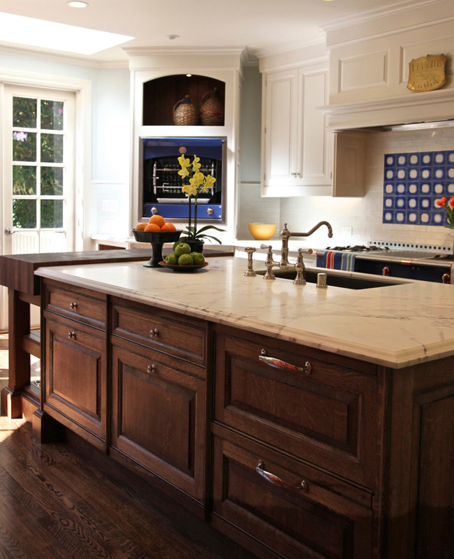 Example of a classic medium tone wood floor eat-in kitchen design in San Francisco with an integrated sink, raised-panel cabinets, medium tone wood cabinets, blue backsplash and an island