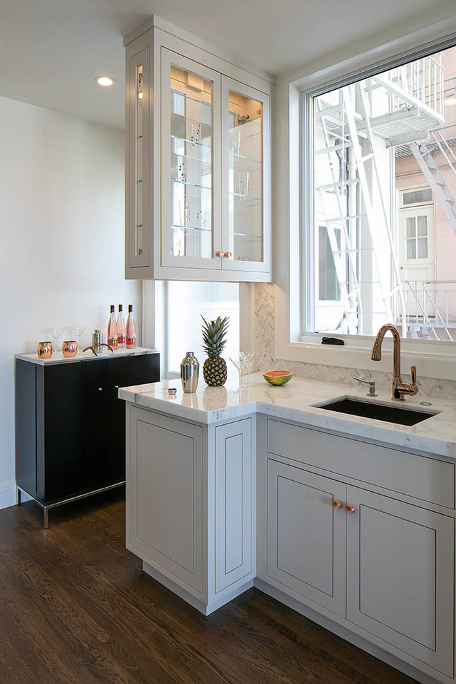 Стильный дизайн: кухня в стиле неоклассика (современная классика) с врезной мойкой, плоскими фасадами, серыми фасадами, серым фартуком, темным паркетным полом и мойкой у окна - последний тренд