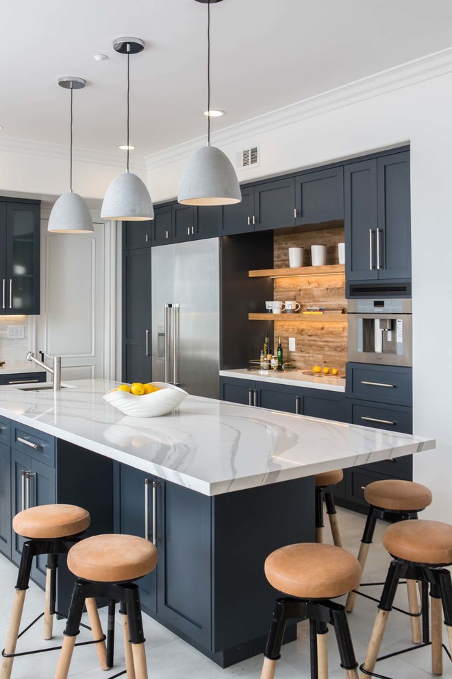 Immagine di un cucina con isola centrale classico con lavello sottopiano, ante in stile shaker, ante nere, pavimento grigio, top bianco e paraspruzzi marrone