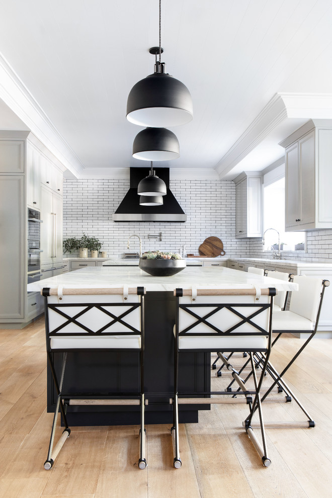 Eat-in kitchen - large modern u-shaped light wood floor and beige floor eat-in kitchen idea in New York with shaker cabinets, gray cabinets, marble countertops, white backsplash, two islands and white countertops