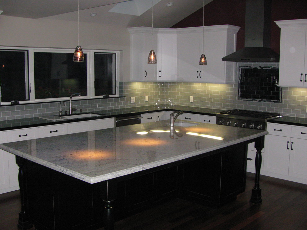 Klassische Küche mit weißen Schränken, Küchenrückwand in Grau, Küchengeräten aus Edelstahl, braunem Holzboden und Kücheninsel in Los Angeles