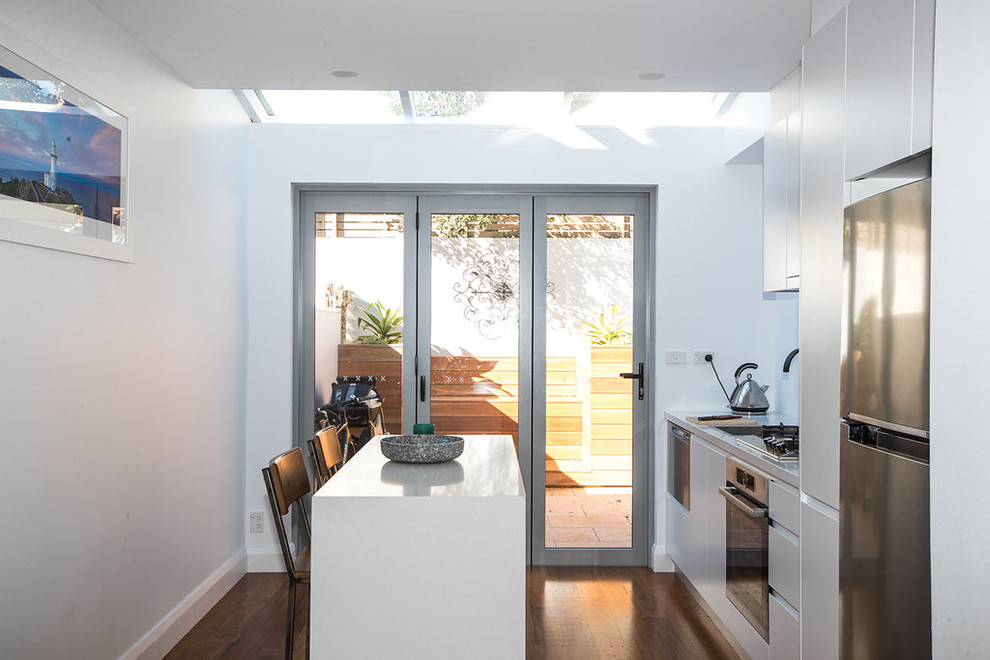 Immagine di una piccola cucina con lavello integrato, ante a persiana, ante bianche, top in granito, elettrodomestici in acciaio inossidabile e parquet scuro