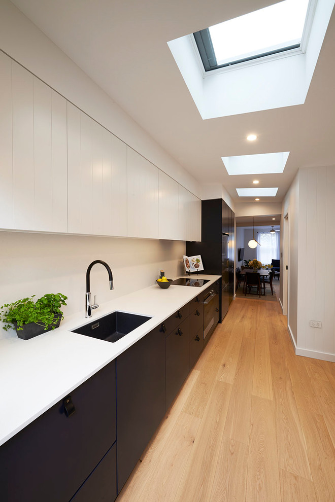 Example of a small minimalist single-wall light wood floor and brown floor eat-in kitchen design in Sydney with an undermount sink, flat-panel cabinets, black cabinets, quartz countertops, gray backsplash, stone slab backsplash, stainless steel appliances, no island and gray countertops