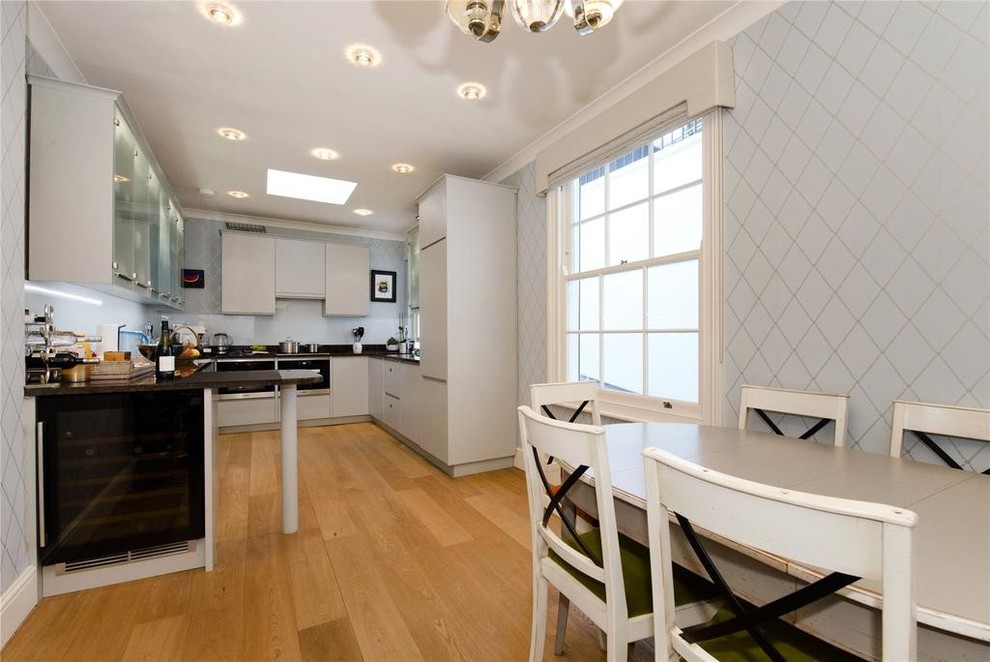 Photo of a medium sized classic u-shaped kitchen in London with flat-panel cabinets.