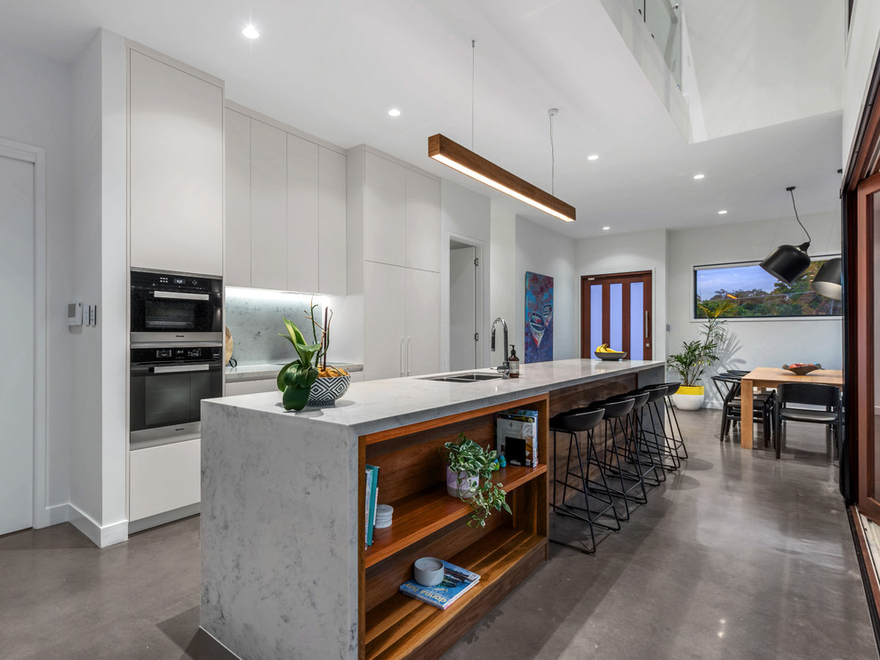 Zweizeilige, Mittelgroße Moderne Küche mit Unterbauwaschbecken, Betonboden, Kücheninsel und grauem Boden in Brisbane