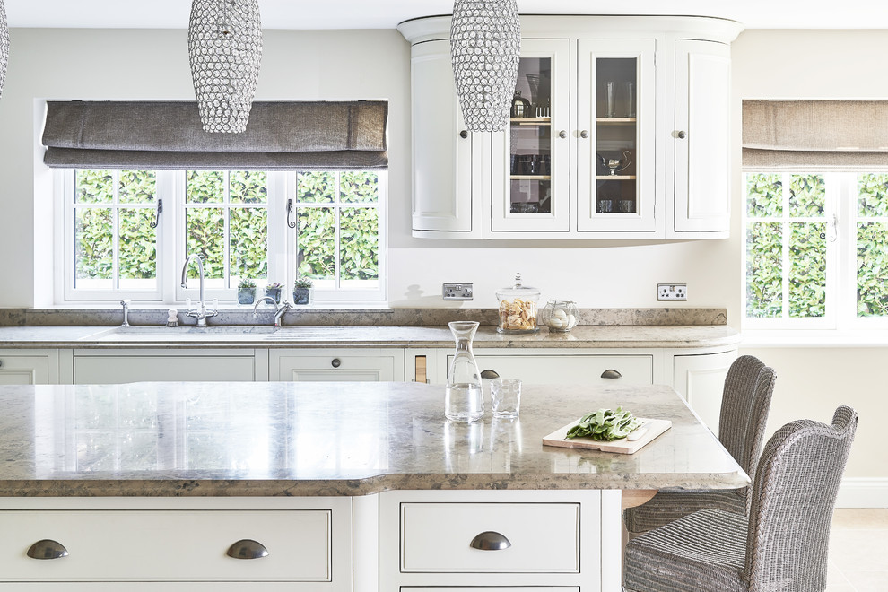 Design ideas for a large traditional u-shaped kitchen/diner in Berkshire with a belfast sink, shaker cabinets, white cabinets, limestone worktops, multi-coloured splashback, glass sheet splashback, coloured appliances, limestone flooring and an island.