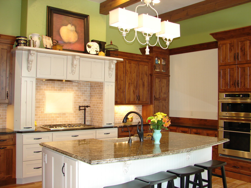 Example of a farmhouse u-shaped eat-in kitchen design in Denver with a farmhouse sink, shaker cabinets, medium tone wood cabinets, granite countertops, beige backsplash and stainless steel appliances