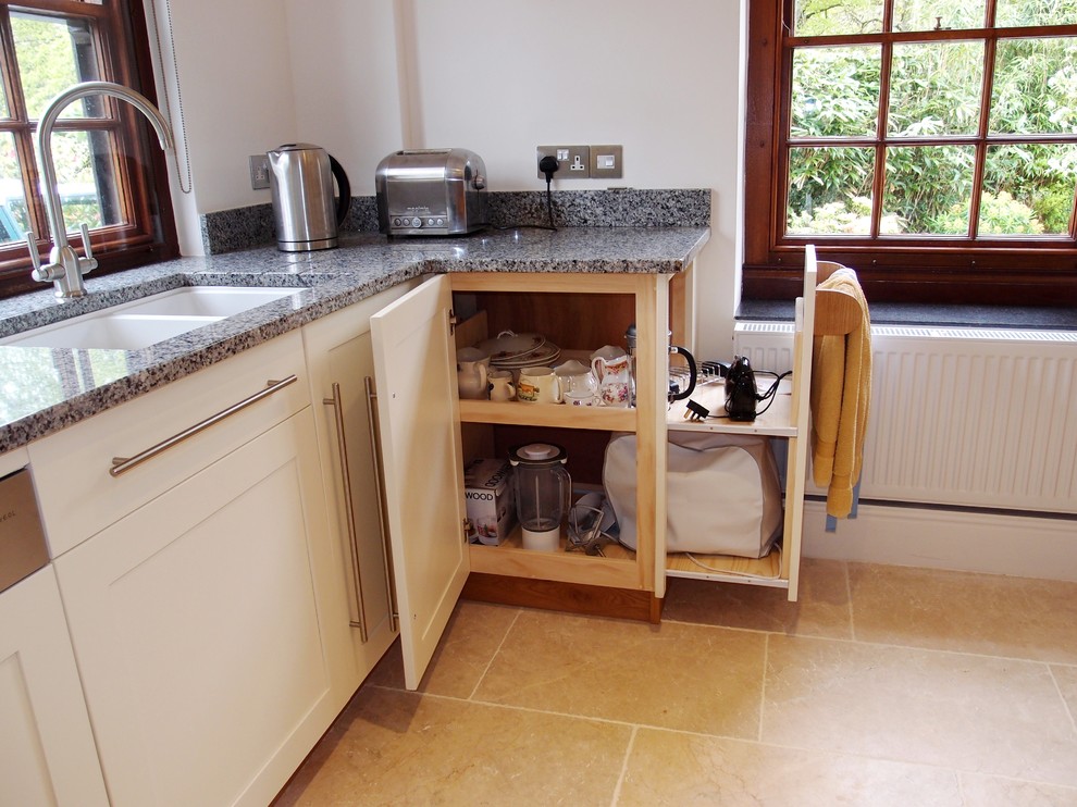 Ejemplo de cocinas en L campestre grande con armarios estilo shaker, puertas de armario blancas y encimera de granito