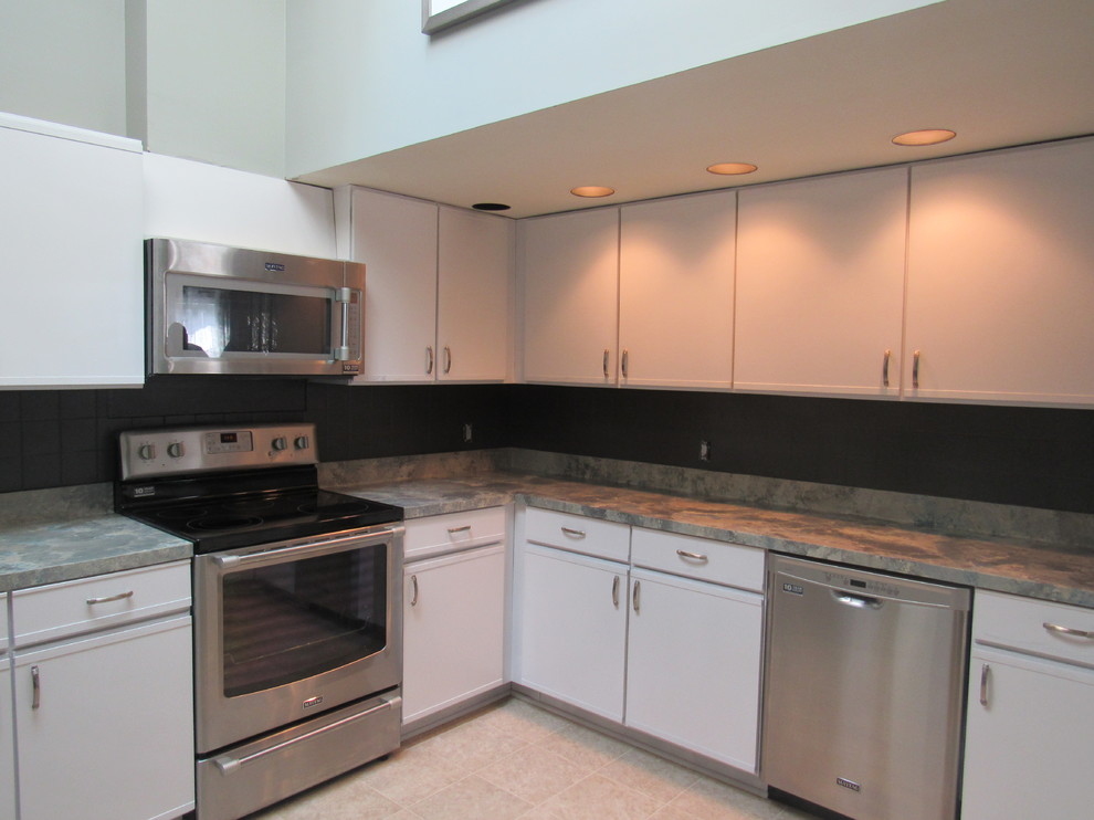 Photo of a small traditional l-shaped enclosed kitchen in DC Metro with flat-panel cabinets, white cabinets, laminate countertops, grey splashback, cement tile splashback and no island.