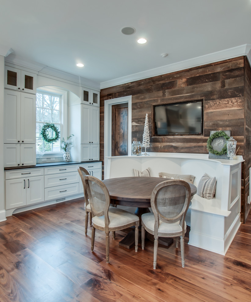 Inspiration for a large shabby-chic style u-shaped medium tone wood floor eat-in kitchen remodel in Wichita with a farmhouse sink, recessed-panel cabinets, white cabinets, marble countertops, beige backsplash, subway tile backsplash, stainless steel appliances and an island