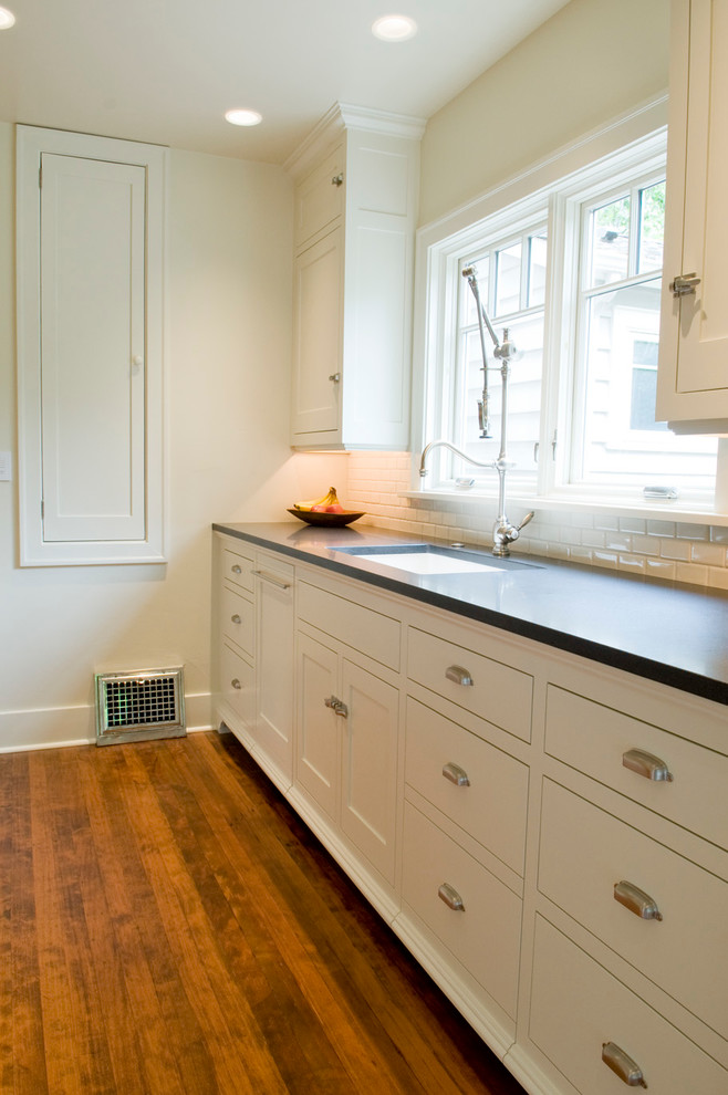 Inspiration for a timeless u-shaped eat-in kitchen remodel in Seattle with an undermount sink, recessed-panel cabinets, white cabinets, granite countertops, white backsplash, subway tile backsplash and paneled appliances