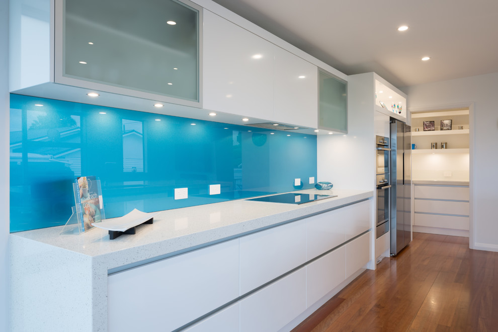 Idee per una cucina contemporanea con paraspruzzi blu e paraspruzzi con lastra di vetro