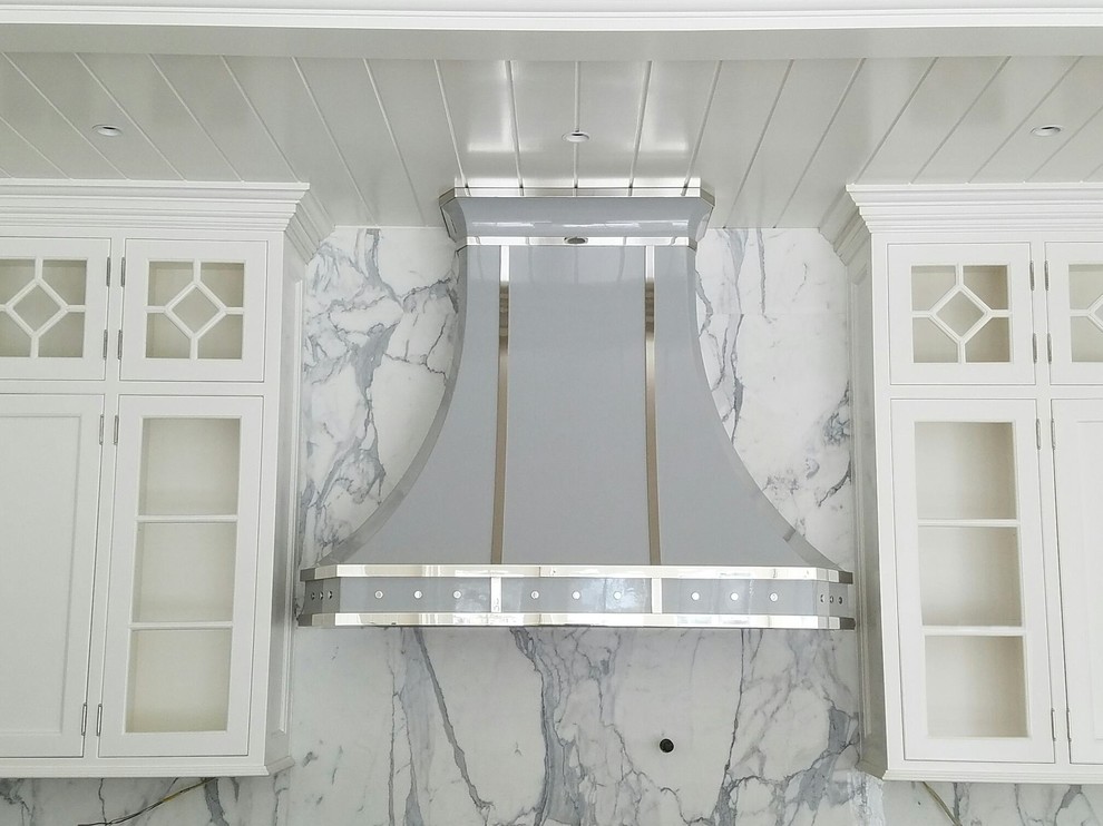 Minimalist kitchen photo in New York with white backsplash, marble backsplash and stainless steel appliances