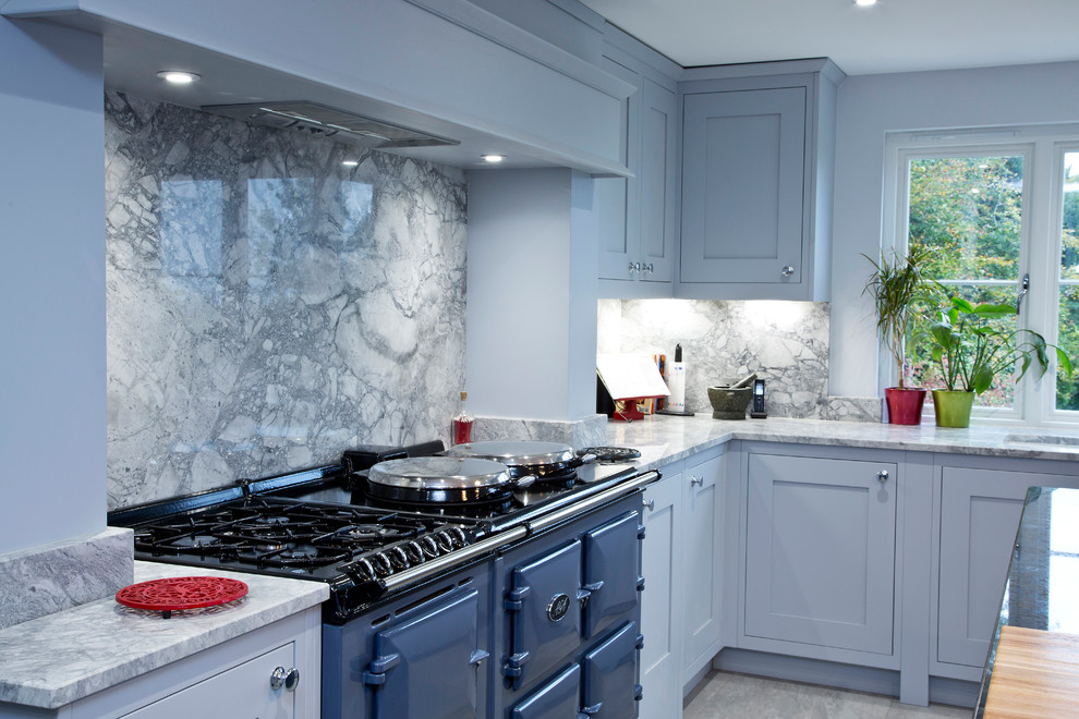 Example of a large transitional u-shaped enclosed kitchen design in Kent with a drop-in sink, shaker cabinets, granite countertops, gray backsplash, stone slab backsplash and an island