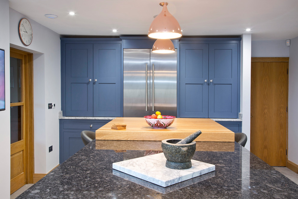 This is an example of a large classic u-shaped enclosed kitchen in Kent with a built-in sink, shaker cabinets, granite worktops, grey splashback, stone slab splashback and an island.