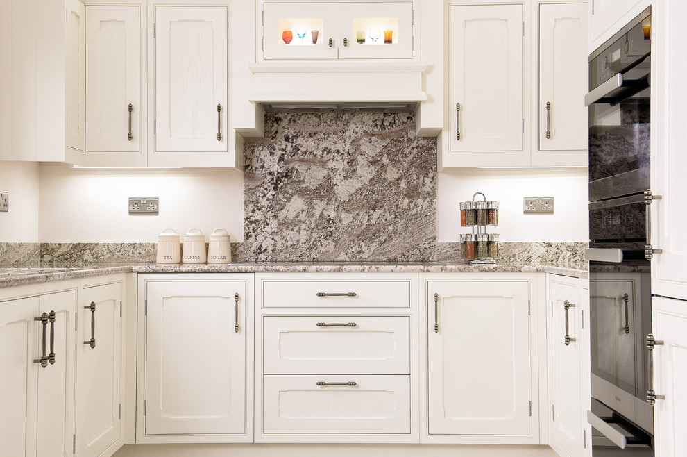 Example of a mid-sized classic u-shaped terra-cotta tile eat-in kitchen design in Other with an undermount sink, beaded inset cabinets, granite countertops and stainless steel appliances