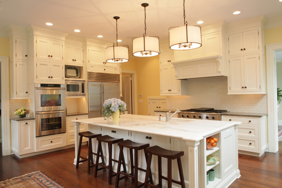 Kitchen - traditional kitchen idea in New York with stainless steel appliances, recessed-panel cabinets, white cabinets, marble countertops, white backsplash and subway tile backsplash