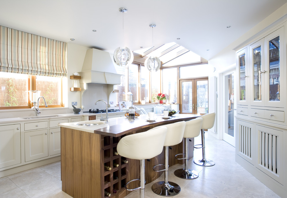 Example of a transitional enclosed kitchen design in Dublin with recessed-panel cabinets and white cabinets