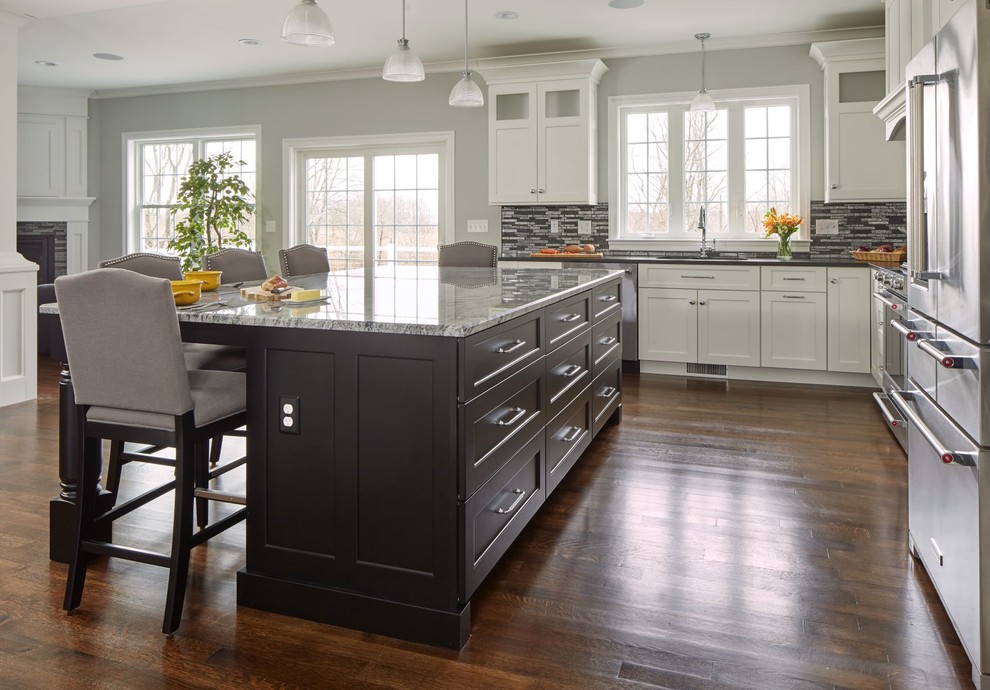 Foto de cocina clásica renovada grande con electrodomésticos de acero inoxidable, suelo de madera en tonos medios, una isla y encimeras multicolor