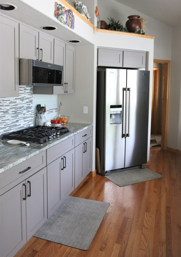 Foto på ett mellanstort funkis flerfärgad kök, med en rustik diskho, skåp i shakerstil, grå skåp, granitbänkskiva, blått stänkskydd, stänkskydd i tunnelbanekakel, rostfria vitvaror, ljust trägolv, en halv köksö och brunt golv