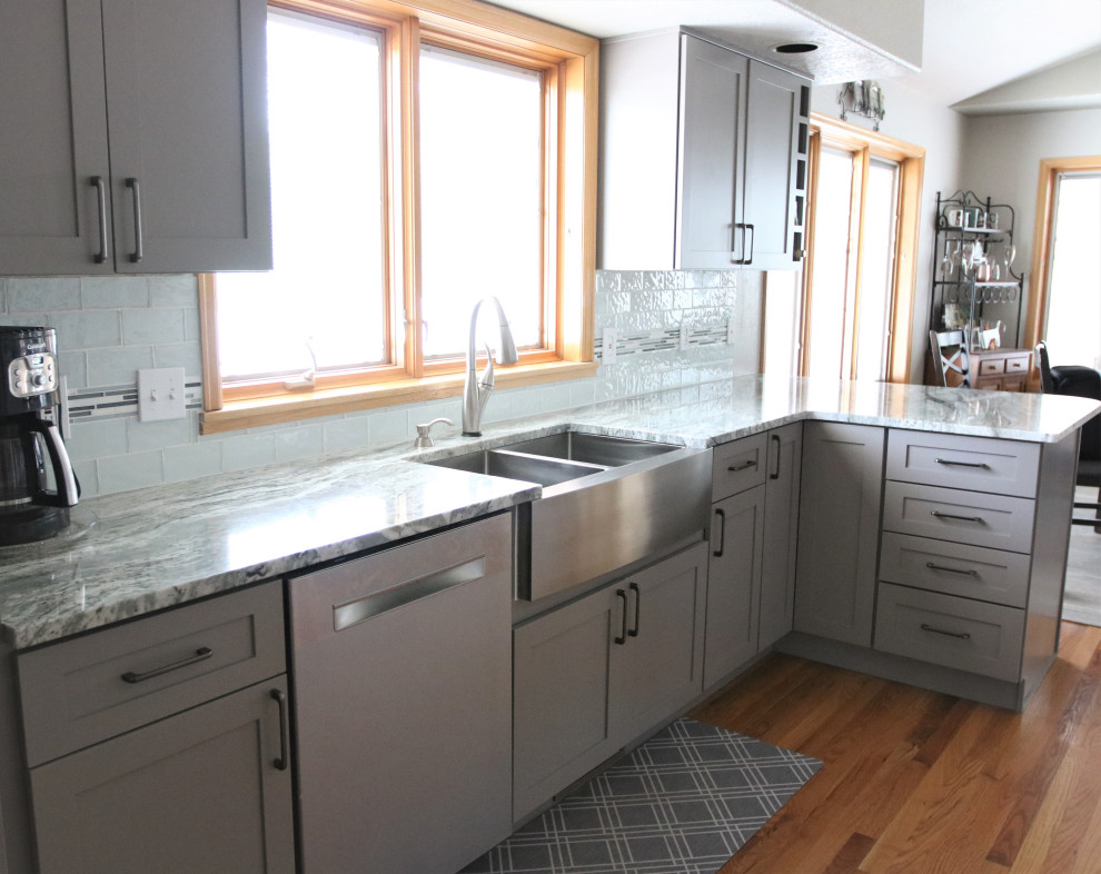 Idéer för att renovera ett mellanstort funkis flerfärgad flerfärgat kök, med en rustik diskho, skåp i shakerstil, grå skåp, granitbänkskiva, blått stänkskydd, stänkskydd i tunnelbanekakel, rostfria vitvaror, ljust trägolv, en halv köksö och brunt golv