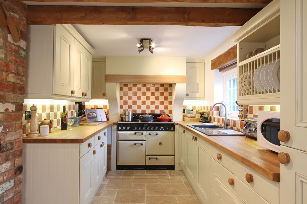 Example of a mountain style enclosed kitchen design in Hampshire with wood countertops, white appliances and a drop-in sink