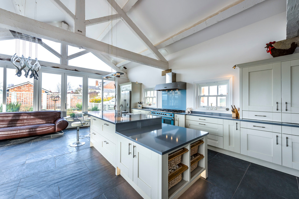 Foto på ett lantligt kök med öppen planlösning, med skåp i shakerstil, vita skåp, blått stänkskydd, glaspanel som stänkskydd, färgglada vitvaror och en köksö