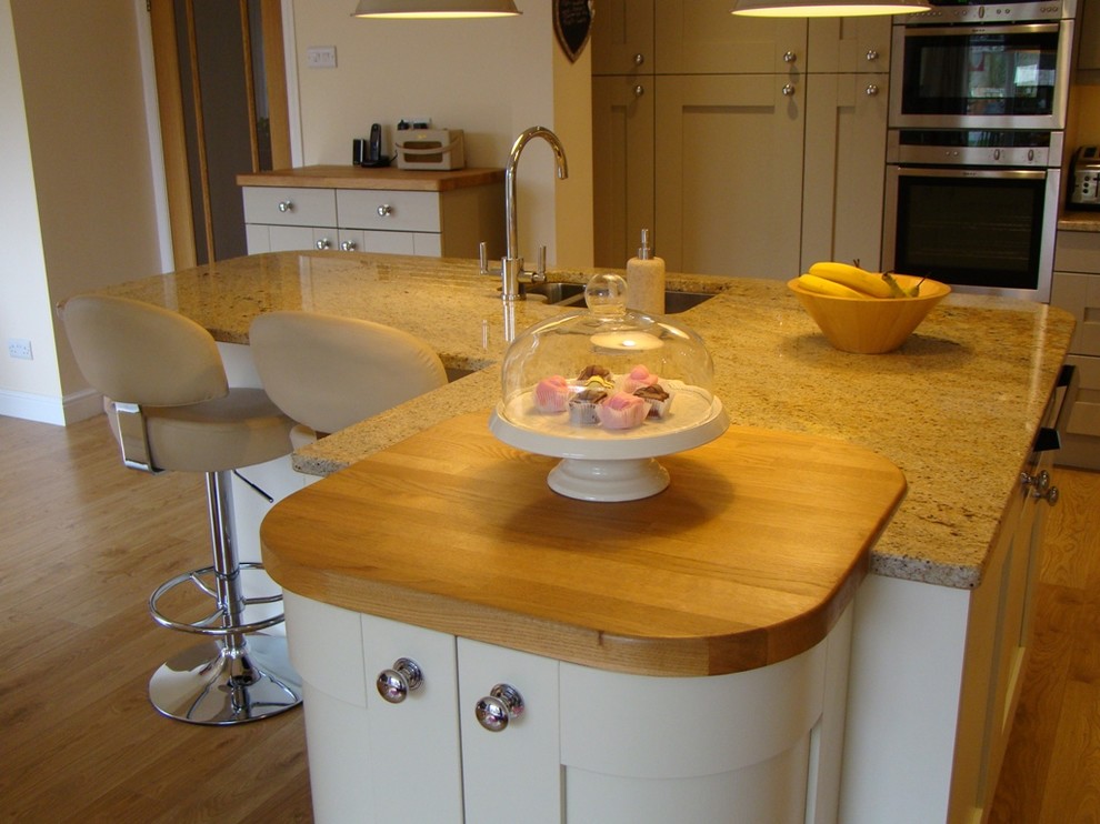 Foto di una grande cucina bohémian con lavello da incasso, ante in stile shaker, ante grigie, top in granito, elettrodomestici da incasso e parquet chiaro