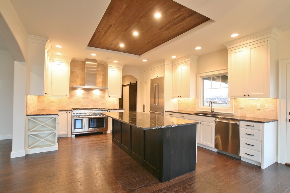 Eat-in kitchen - mid-sized transitional u-shaped dark wood floor and brown floor eat-in kitchen idea in Chicago with an undermount sink, shaker cabinets, white cabinets, granite countertops, beige backsplash, ceramic backsplash, stainless steel appliances and an island