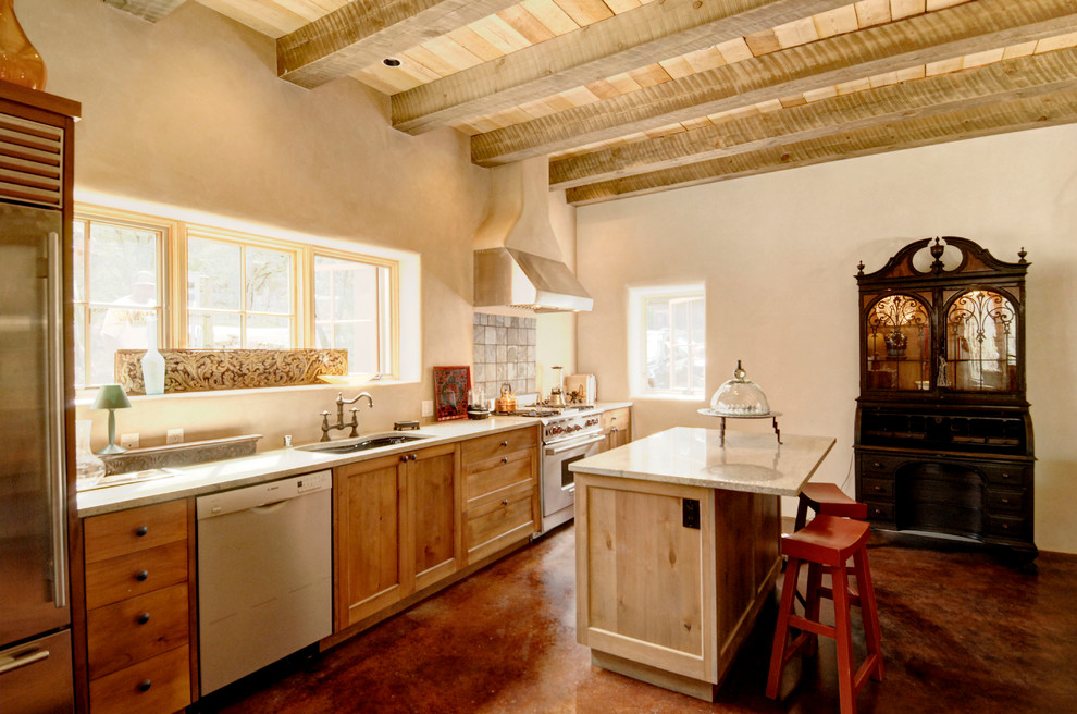 Aménagement d'une cuisine linéaire sud-ouest américain avec un évier encastré, un placard à porte shaker, un plan de travail en granite, une crédence beige et un électroménager en acier inoxydable.