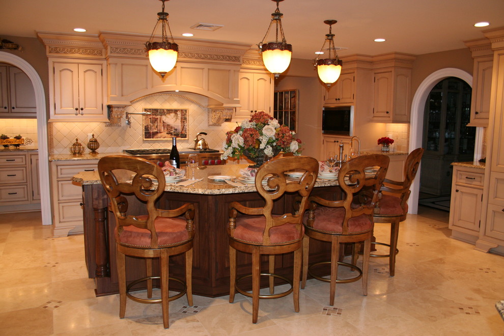 Medelhavsstil inredning av ett stort kök och matrum, med en köksö, en undermonterad diskho, luckor med infälld panel, gula skåp, granitbänkskiva, beige stänkskydd och marmorgolv