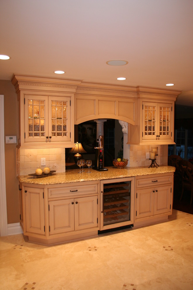 Photo of a large traditional kitchen/diner in New York with a submerged sink, recessed-panel cabinets, yellow cabinets, granite worktops, beige splashback, marble flooring and an island.