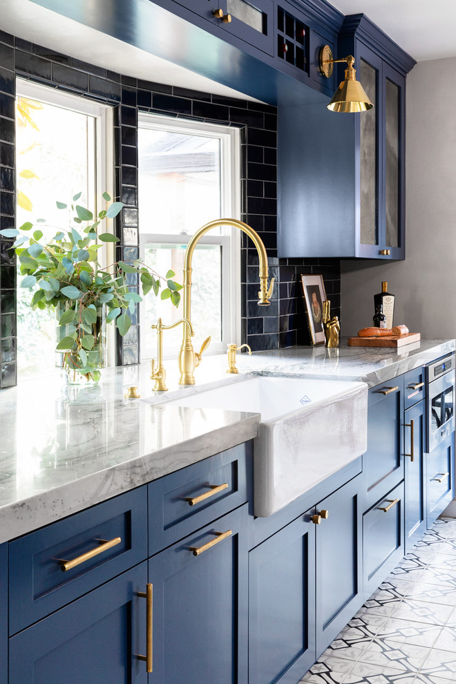 Small modern kitchen in San Diego with a belfast sink, shaker cabinets, blue cabinets, quartz worktops, blue splashback, ceramic splashback, stainless steel appliances, cement flooring, grey floors and grey worktops.