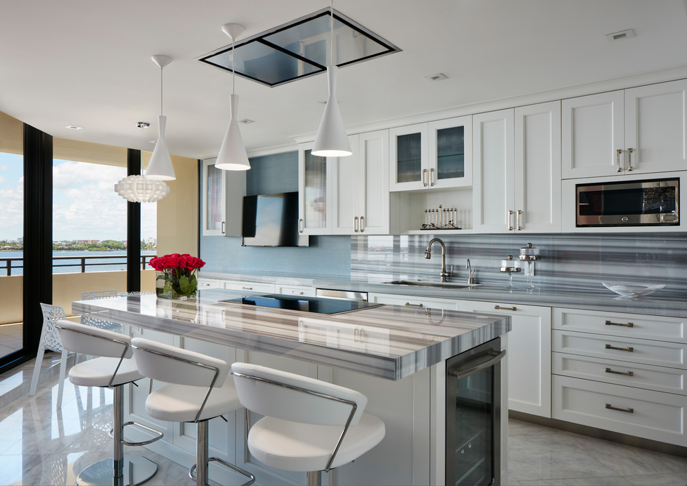 Classic kitchen in Miami with a submerged sink, recessed-panel cabinets, white cabinets, multi-coloured splashback, stainless steel appliances and an island.