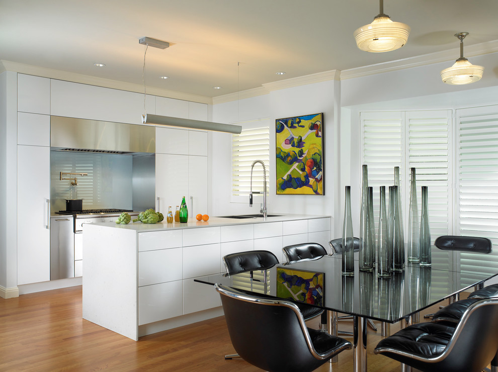Bild på ett funkis kök, med integrerade vitvaror, släta luckor, vita skåp och glaspanel som stänkskydd
