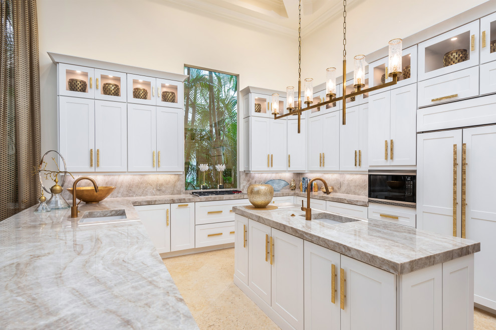 Moderne Küche in U-Form mit Unterbauwaschbecken, Schrankfronten im Shaker-Stil, weißen Schränken, Küchenrückwand in Grau, Elektrogeräten mit Frontblende, Kücheninsel, beigem Boden und grauer Arbeitsplatte in Miami