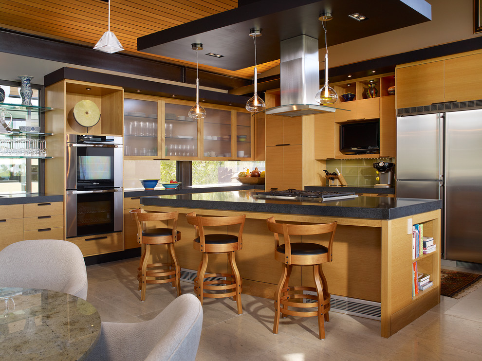 Moderne Küche in L-Form mit flächenbündigen Schrankfronten, hellbraunen Holzschränken, Küchenrückwand in Grün und Küchengeräten aus Edelstahl in Los Angeles