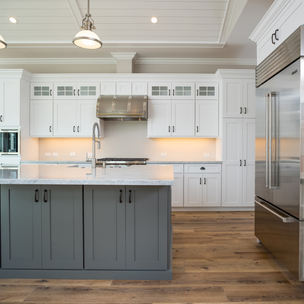 Idéer för att renovera ett stort vintage grå grått l-kök, med en rustik diskho, skåp i shakerstil, marmorbänkskiva, en köksö, brunt golv, vita skåp, rostfria vitvaror och vinylgolv