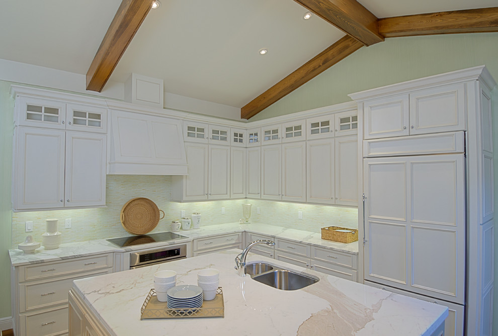 Modelo de cocina clásica de tamaño medio con puertas de armario blancas, encimera de granito, salpicadero blanco, suelo de madera en tonos medios y una isla